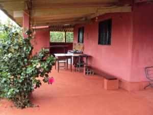 Sitio Sao Benedito في ساو روكي دي ميناس: غرفة بجدار وردي مع طاولة ومصنع