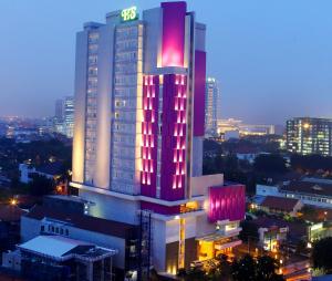 un grand bâtiment avec des lumières rouges au-dessus dans l'établissement Hotel Santika Premiere Gubeng Surabaya, à Surabaya