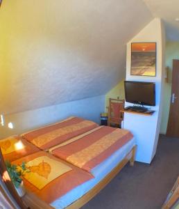 1 dormitorio con 1 cama y TV de pantalla plana en Gemütliches Zimmer zentral in der Lüneburger Heide en Schneverdingen