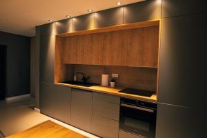a kitchen with stainless steel appliances and wooden cabinets at Thome Arena Residence in Cluj-Napoca