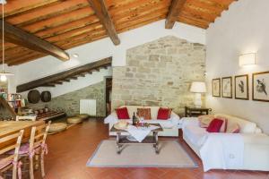 a living room with white furniture and a stone wall at Agriresort La Noce di Francesca in Londa