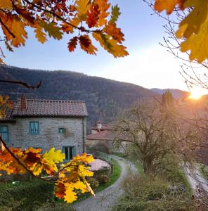 a stone house in the mountains with the sun setting at Agriresort La Noce di Francesca in Londa