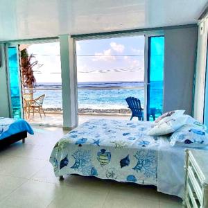 CASA ENEIDA -SAN ANDRES ISLA في سان أندريس: غرفة نوم مع سرير وإطلالة على المحيط