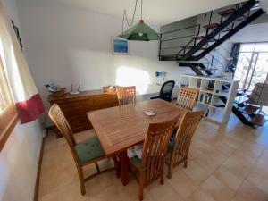 una cucina e una sala da pranzo con tavolo e sedie in legno di Casa Neem - Duplex 2ch dans village naturiste a Charco del Palo