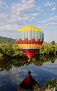 balon z gorącym powietrzem latający nad wodą w obiekcie Villa Mont Joie w mieście Beynac-et-Cazenac