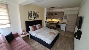 a small bedroom with a bed and a couch at Galata Apartment in Novi Pazar