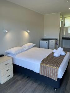 1 dormitorio con 1 cama grande y toallas. en Queens Beach Hotel, en Bowen