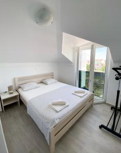 a bedroom with a bed and a large window at Luminus Apartments in Srima