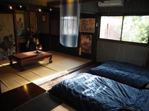 a bedroom with two beds and a table in it at 民泊カフェ Gootarian in Kumamoto