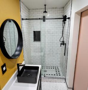 baño con lavabo negro y espejo en The Bell Vista, en Burbank