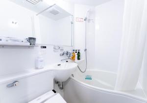 a white bathroom with a sink and a shower at APA Hotel Yodoyabashi Kitahama Ekimae in Osaka