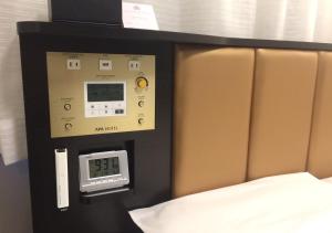 a room with a bed and a clock on the wall at APA Hotel Yodoyabashi Kitahama Ekimae in Osaka