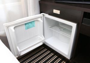 an empty refrigerator with its door open in a kitchen at APA Hotel Yodoyabashi Kitahama Ekimae in Osaka