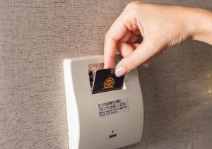 a hand is pushing a button on a lightswitch at APA Hotel Yodoyabashi Kitahama Ekimae in Osaka