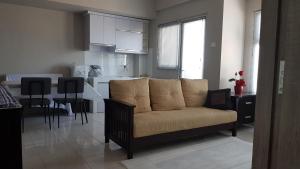 a living room with a couch and a kitchen at Apartemen Newton Kayla in Bandung