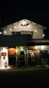 a bar with a sign on the side of it at night at 民泊カフェ Gootarian in Kumamoto