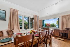 a dining room with a table and chairs at Winstone Cottage - Waterfront Lake Tarawera Home in Lake Tarawera