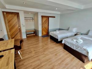 um quarto com 2 camas e piso em madeira em Baan Arunothai Homestay em Phayao