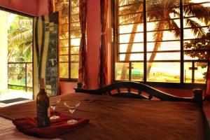 una botella de vino sentada en una mesa con copas en This is it Beachfront - Rooms, Cafe & Events en Arambol