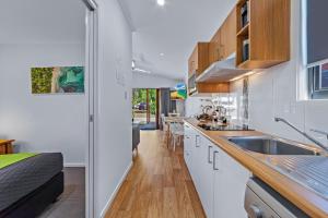 a kitchen with white cabinets and a sink at BIG4 Whitsundays Tropical Eco Resort in Airlie Beach