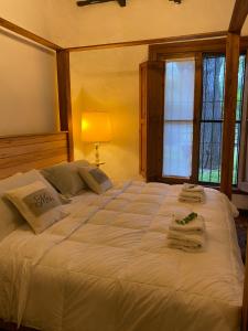 a bedroom with a large white bed with towels on it at Don Aniceto - Suites de Campo in Luján