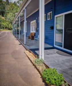 una casa blu con portico con tavolo e sedie di Edlin House a Bright