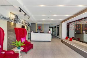 a lobby with a red chair and a reception desk at RedDoorz Plus @ Jones Avenue Cebu in Cebu City