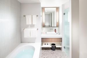 bagno con vasca, lavandino e specchio di Majestic M Suites a Adelaide Altre 10 foto