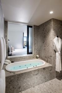 uma banheira na casa de banho com uma janela em Majestic M Suites em Adelaide