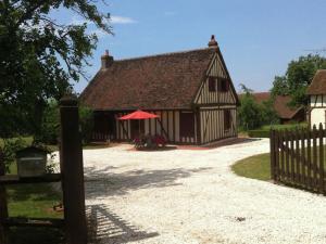 un edificio con una sombrilla roja junto a una valla en Holiday home with garden, en Fontainejean