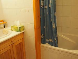 y baño con cortina de ducha, lavabo y bañera. en Charming chalet with view on Mont Blanc en Peisey-Nancroix