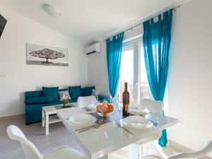 comedor con cortinas azules, mesa y sillas en Lavish Apartment in Omi alj with Rooftop Terrace, en Omišalj