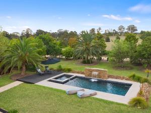 a swimming pool in a yard with chairs and an umbrella at Lilies Luxe Suite on Lovedale with Private Heated Pool 5star in Lovedale