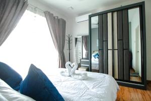 ein Schlafzimmer mit zwei weißen Schwänen auf einem Bett in der Unterkunft Amjad Homestay in Kota Bharu