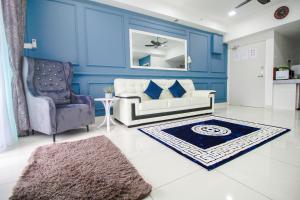 a blue living room with a couch and a chair at Amjad Homestay in Kota Bharu