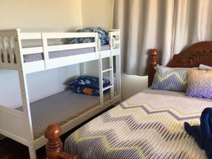 a bedroom with two bunk beds and a bed at Best Beach Villa in Denham