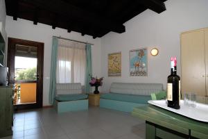 salon z kanapami i butelką wina w obiekcie Residence Portorotondo Tre w mieście Porto Rotondo
