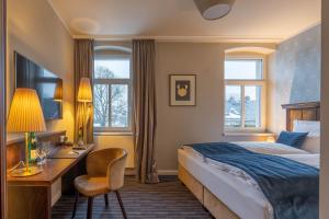 una camera d'albergo con letto e scrivania di Logis Hotel QUARTIER 5, Sächsische Schweiz, mit Restaurant, Café & Bar a Kurort Gohrisch