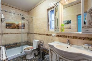 a bathroom with a toilet and a sink and a shower at Guest House Vostryakovo in Domodedovo