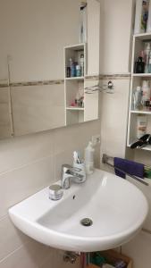 La salle de bains est pourvue d'un lavabo blanc et d'un miroir. dans l'établissement Sotto le stelle, à Cursi