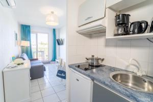 a kitchen with a sink and a counter top at Olydea le Neptune Saint Pierre la mer in Saint Pierre La Mer