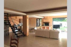 sala de estar con sofá y escalera en VILLA FOUR SEASONS - TERRAZZA SUL MARE, en Trivio