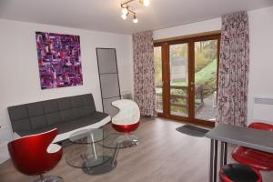 uma sala de estar com um sofá e cadeiras vermelhas em Domaine "Les Hochets em Vresse-sur-Semois