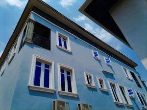 un edificio azul con ventanas y banderas blancas en Big Ocean Inn en Ibadán