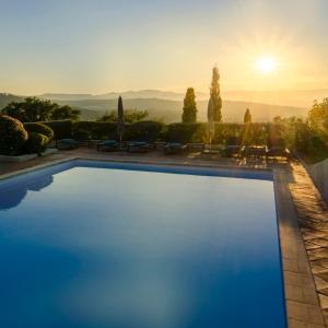 a swimming pool with a sunset in the background at Maison Caroline - Villa 10 personnes avec piscine à 5km de Saint Tropez in Saint-Tropez