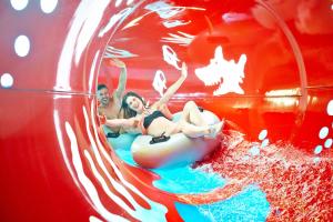 Ein Mann und eine Frau reiten auf einem Schlauch in einem Wasserpark. in der Unterkunft Ferien- und Freizeitpark Weissenhäuser Strand in Weissenhäuser Strand