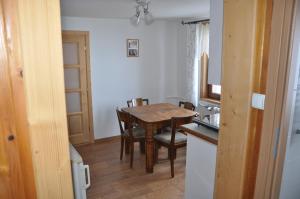 a kitchen and dining room with a table and chairs at Pod Limbą in Jurgów