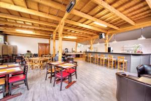 a restaurant with wooden ceilings and tables and chairs at Hôtel Olydea Les Epesses - à 2,5km du PuyDuFou in Les Épesses +19 photos