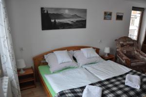 1 dormitorio con 1 cama con manta y silla en Pod limbą, en Jurgów