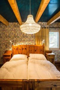 a bedroom with a large bed and a chandelier at Südalpen Lofts in Bleiburg